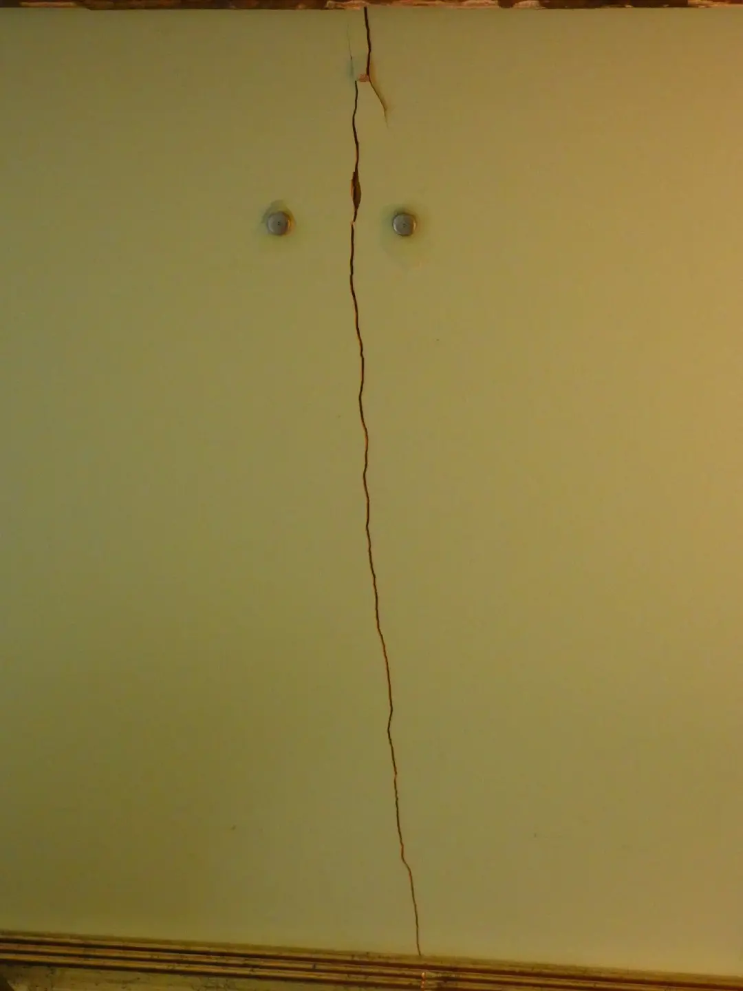 Long crack running down a painted wall