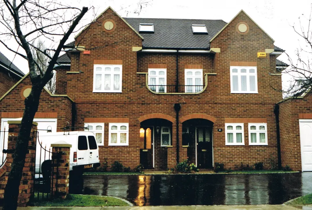 Row of new red brick houses with gabled roofs