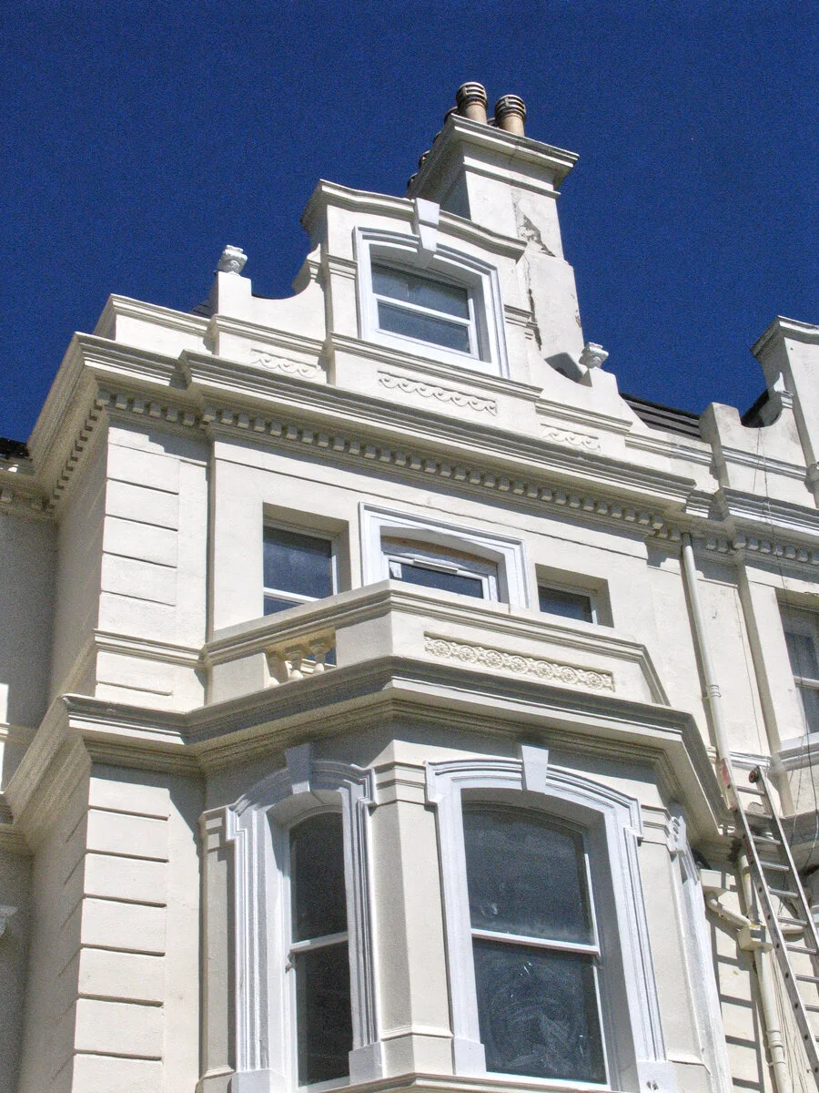 Ornate white period facade with a decorative gable